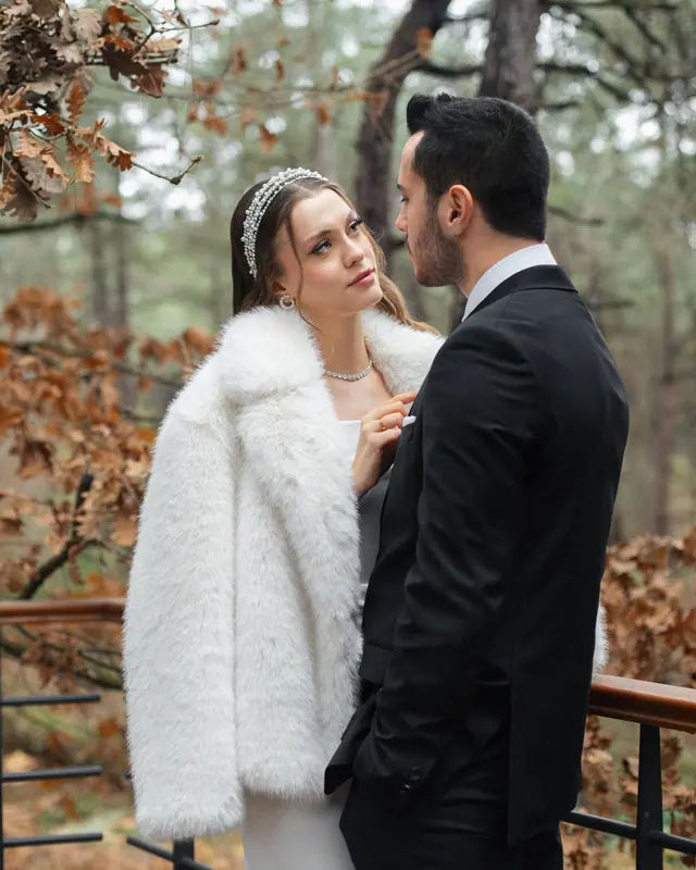 Bride in a white fur coat and groom among autumn leaves — Zarif Film winter offer